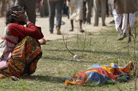 A woman cries next to a body of victim killed during Madhya Pradesh temple stampede