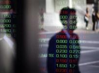 a-man-is-reflected-in-a-window-as-he-walks-past-the-indicator-boards-at-the-australian-stock-exchange-in-sydney-august-11-2011