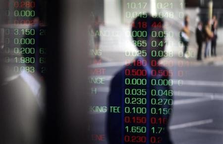 A man is reflected in a window as he walks past the indicator boards at the Australian Stock Exchange in Sydney August 11, 2011.