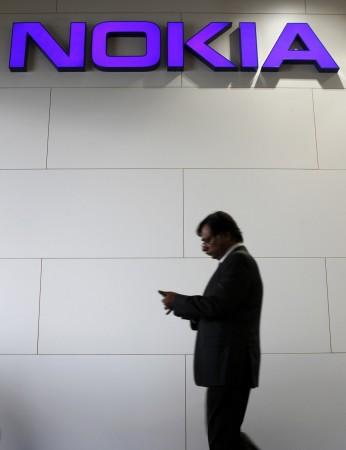 File picture shows a man walking past a Nokia logo during the Mobile World Congress in Barcelona, February 28, 2012. File Picture Shows a Man Walking Past a Nokia Logo During the Mobile World Congress in Barcelona