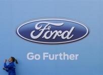 a-woman-has-a-drink-as-she-walks-past-a-logo-of-carmaker-ford-at-the-entrance-to-a-media-event-for-the-launch-of-a-concept-car-in-sydney-august-13-2013
