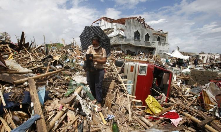 A woman retrieves a teddy bear amongst the debris in the aftermath of super typhoon Haiyan in Tanauan Typhoon Haiyan