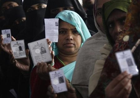 Voters display their voter identity cards as they wait for their turn to cast their ballot at a polling station in Uttar Pradesh. (Representational image)