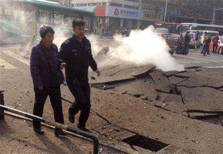 Policeman accompanies a woman after the oil pipeline exploded in China Policeman accompanies a woman after the oil pipeline exploded in China