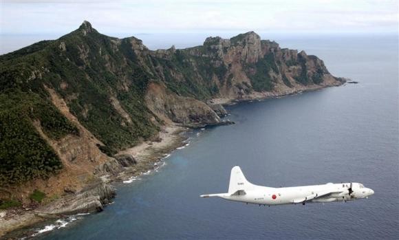 Japan Maritime Self-Defense Force's PC3 surveillance plane flies around the disputed islands in the East China Sea, known as the Senkaku isles in Japan and Diaoyu in China, in this October 13, 2011 file photo.