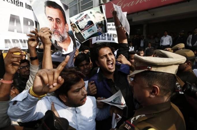 Activists of the Akhil Bharatiya Vidyarthi Parishad (ABVP), linked to India's main opposition Bharatiya Janata Party (BJP), holding posters of Tarun Tejpal, editor-in-chief of India's leading investigative magazine, shout slogans as police try t