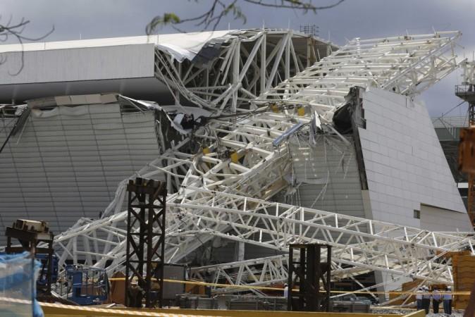 Workers stand near a crane that collapsed on the site of the Arena Sao Paulo stadium, known as  Arena Sao Paulo stadium