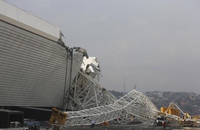 Workers stand near a crane that collapsed on the site of the Arena Sao Paulo stadium, known as Arena Sao Paulo stadium
