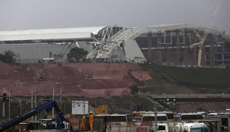 Workers stand near a crane that collapsed on the site of the Arena Sao Paulo stadium, known as Arena Sao Paulo stadium