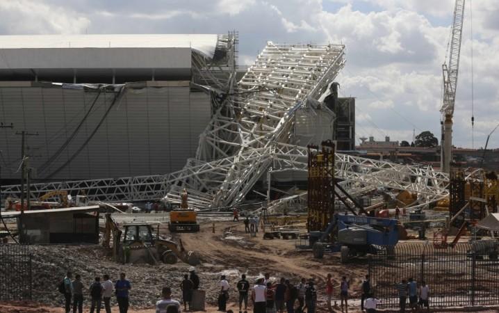 Workers stand near a crane that collapsed on the site of the Arena Sao Paulo stadium, known as Arena Sao Paulo stadium