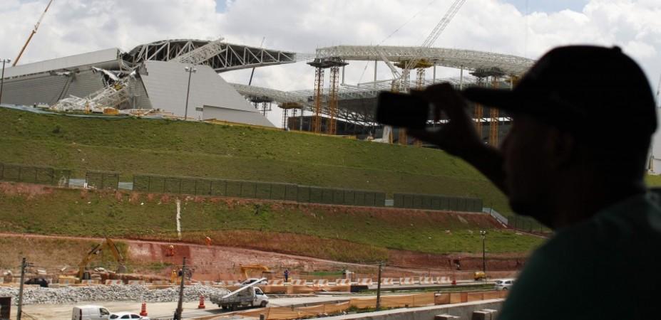 Workers stand near a crane that collapsed on the site of the Arena Sao Paulo stadium, known as Arena Sao Paulo stadium