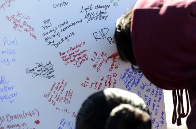 Fans write remembrances at the scene of a fiery crash that killed Paul Walker