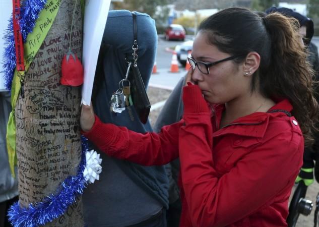 Krysha Converse wipes a tear reading notes written on a tree during an unofficial memorial event for Paul Walker