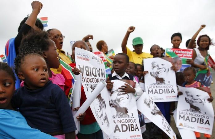 Villagers hold posters as they wait for the funeral cortege carrying the coffin of Mandela, just outside the village of Qunu Nelson Mandela