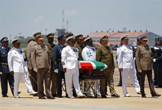 The coffin of former South African President Nelson Mandela is escorted aboard a military cargo plane after a send-off ceremony at Waterkloof Air Force base in Pretoria December 14, 2013 Mandela's Coffin
