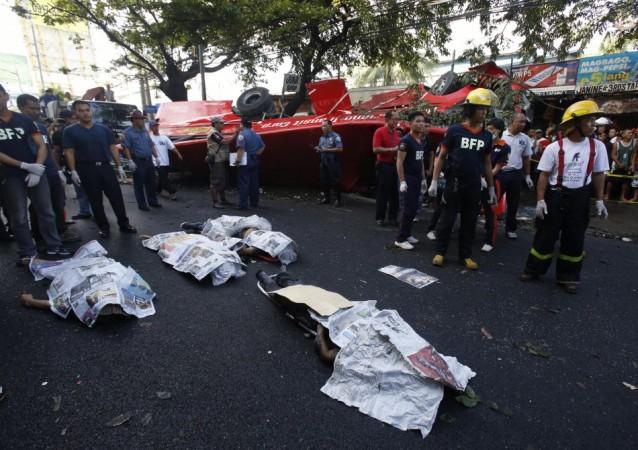 Bodies of passengers lie beside a bus after it fell off an elevated expressway and crashed into a van below in Taguig city, south of Manila December 16, 2013. Bodies of passengers lie beside a bus after it fell off an elevated expressway and crashed into a van below in Taguig city, south of Manila December 16, 2013. At least 21 people were killed during the incident, according to the police.