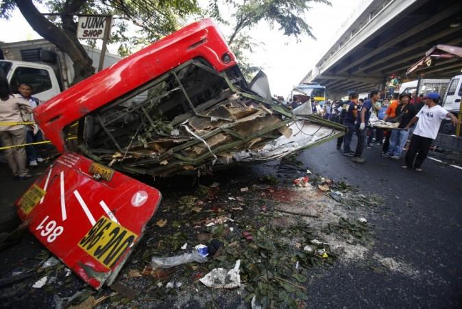 Rescuers carry a body on a stretcher as they walk past a bus after it fell off an elevated expressway and crashed into a van below in Taguig city, south of Manila December 16, 2013. Rescuers carry a body on a stretcher as they walk past a bus after it fell off an elevated expressway and crashed into a van below in Taguig city, south of Manila December 16, 2013.