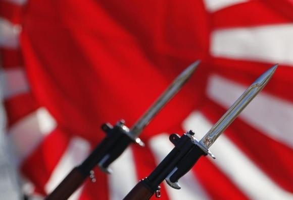 Bayonets attached to rifles used by Japanese Self-Defense Forces are seen in front of Japan's rising sun flag, which is used by the forces, during the annual troop review ceremony at Asaka Base in Asaka, near Tokyo October 27, 2013.