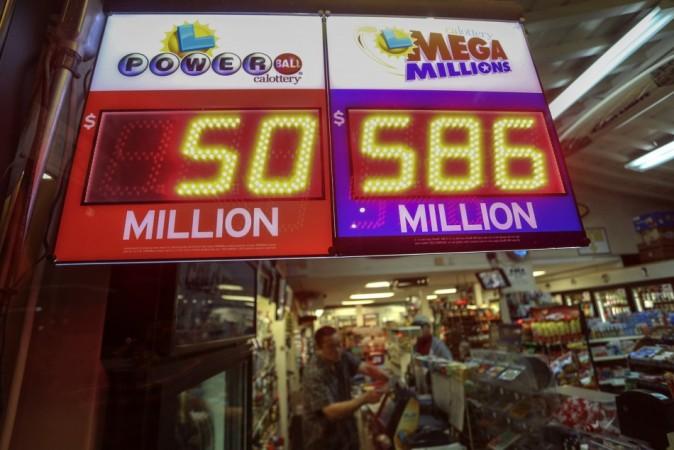 A worker at Nick's Liquor Store sells lottery tickets as a sign shows the Mega Millions jackpot estimated at $586 million in Venice, California Mega Millions Jackpot