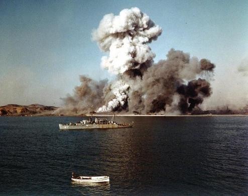 Smoke rises over Hungnam's port area, as facilties and remaining U.N. supplies are demolished by explosives on the final day of evacuation operations during Korean War, December 24, 1950.