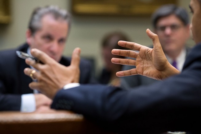 President Barack Obama gestures during a meeting in the Roosevelt Room of the White House, Dec. 18, 2013.