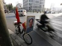 a-resident-rides-past-a-bicycle-bearing-a-portrait-of-china039s-late-chairman-mao-zedong