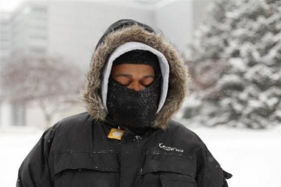 A man waits for a transit bus in several inches of snow in Detroit, Michigan January 2, 2014. A man waits for a transit bus in several inches of snow in Detroit, Michigan January 2, 2014.