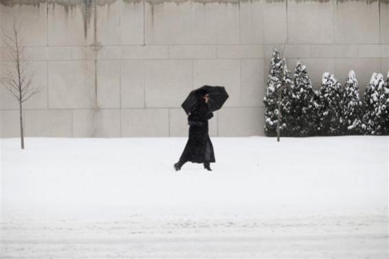 A woman uses a umbrella to protect her from the snow in Detroit, Michigan January 2, 2014. A woman uses a umbrella to protect her from the snow in Detroit, Michigan January 2, 2014.