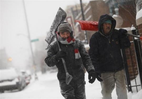 Two men carry shovels as they walk along through several inches of snow in Detroit, Michigan January 2, 2014 Two men carry shovels as they walk along through several inches of snow in Detroit, Michigan January 2, 2014