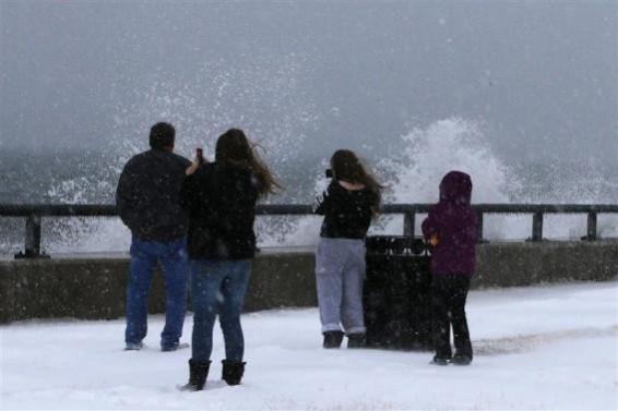 Onlookers look at waves crashing against the seawall around high tide during a winter nor'easter snowstorm in Lynn, Massachusetts January 2, 2014. Onlookers look at waves crashing against the seawall around high tide during a winter nor'easter snowstorm in Lynn, Massachusetts January 2, 2014.
