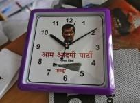 a-wall-clock-carrying-a-portrait-of-arvind-kejriwal-leader-of-the-newly-formed-aam-aadmi-common-man-party-aap-and-party-symbol-of-a-broom-lies-on-a-table-inside-their-party-office-in-new-delhi-october-1-2013