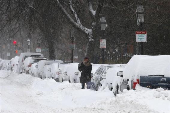 A driver works to dig a car out of the snow during a winter nor'easter snow storm in Boston, Massachusetts January 3, 2014.