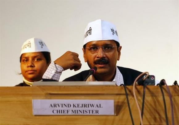 Arvind Kejriwal (R), leader of Aam Aadmi (Common Man) Party, speaks during a meeting with his party leaders and media personnel