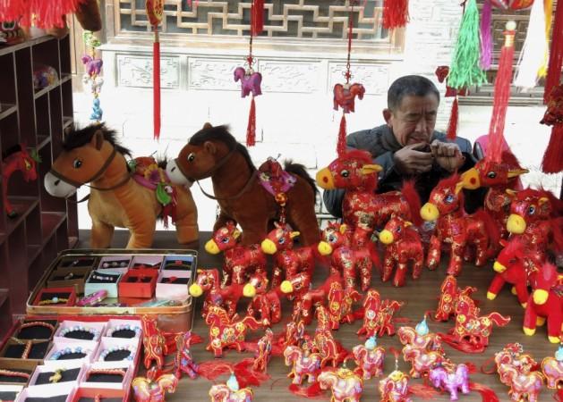 A craftsman makes horse souvenirs at his booth ahead of the upcoming Chinese New Year, in Nanjing, Jiangsu province, January 19, 2014. The Lunar New Year begins on January 31 and marks the start of the Year of the Horse, according to the Chinese zodiac. REUTERS/Sean Yong Chinese New Year 2014