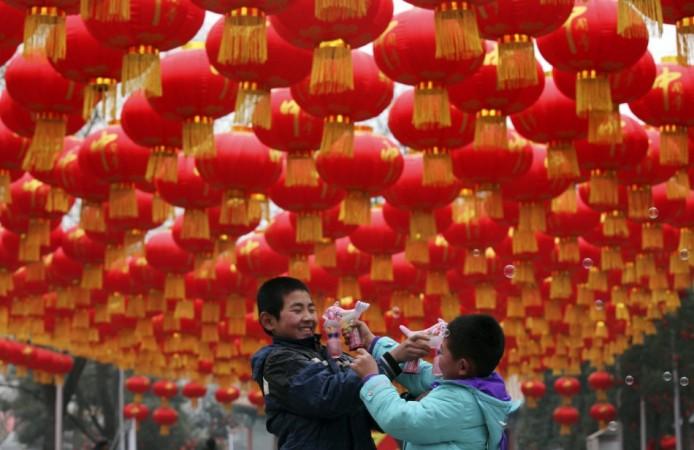 Children play with bubble toy guns under Chinese lunar New Year decorations at a park in Beijing, January 24, 2014. According to the Chinese lunar calendar, the Chinese New Year, which welcomes the year of the horse, falls on January 31. REUTERS/China Daily Chinese New Year 2014