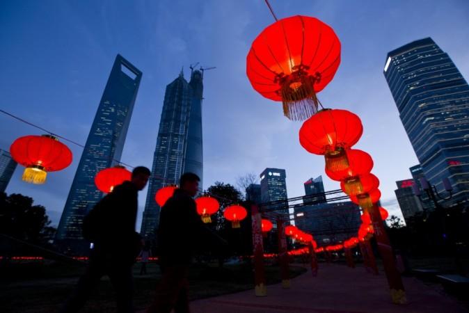 Pedestrians walk under red lanterns which was recently installed as Chinese New Year decorations, at Pudong Financial Area in Shanghai, January 24, 2014. According to the Chinese lunar calendar, the Chinese New Year, which welcomes the year of the horse, kicks off on January 31. Picture taken January 24, 2014. REUTERS/Aly Song Chinese New Year 2014