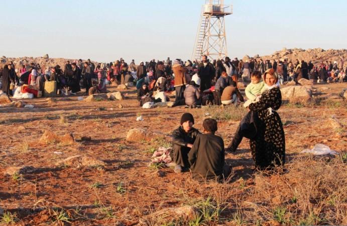 Syrian refugees, fleeing the violence, wait to enter Turkey on the Syrian-Turkish border in Shamm Alqrain village.