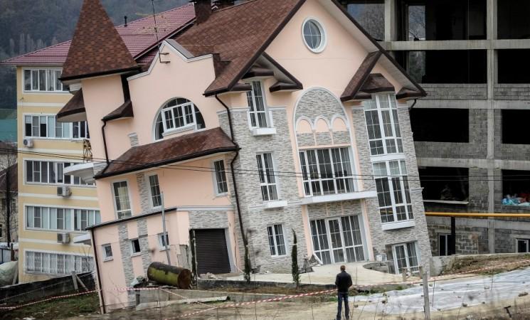 A man looks at a residential house that started leaning after a tunnel collapse in the Russian Black sea resort of Sochi March 4, 2013. The house, unoccupied at the time, began leaning after a tunnel on a nearby road construction project fell in on Monday, according to local news reports. (Reuters) Sochi