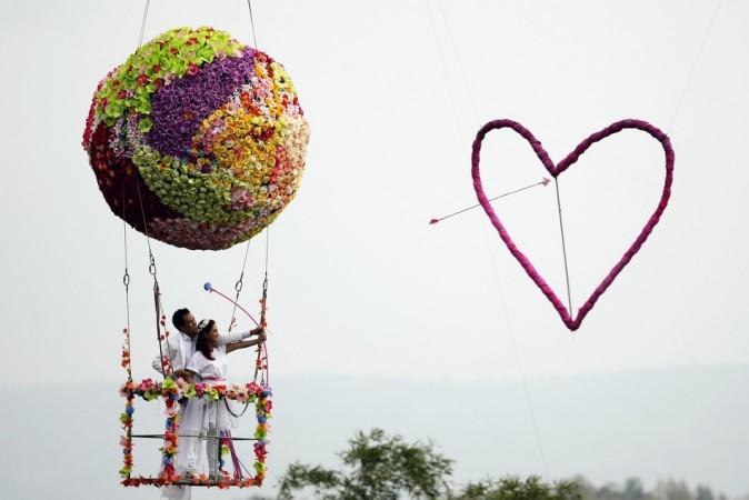Groom Roongroj Walailuk and bride Vina Wichan shoot an arrow during a wedding ceremony ahead of Valentine's Day in Prachin Buri province, east of Bangkok February 13, 2014. (Reuters) Valentine's Day