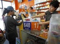 store-owner-jean-shin-places-a-sign-with-the-updated-jackpot-at-the-town-country-news-stand-in-los-angeles-california-march-30-2012