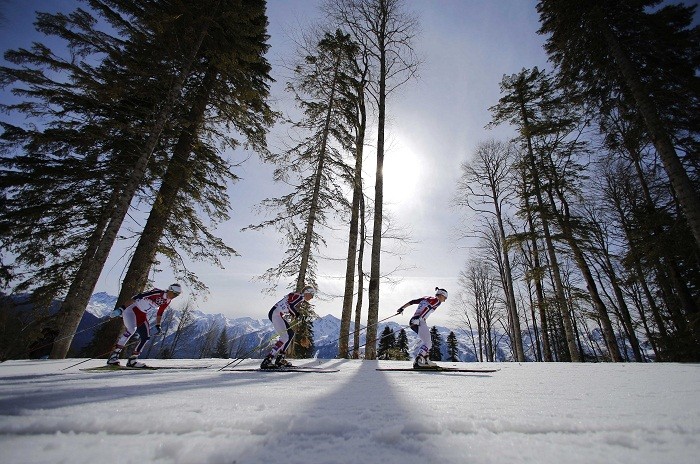 Norway's Therese Johaug, Kristin Stoermer Steira and Marit Bjoergen (R-L) lead during the women's cross-country 30 km mass start free event at the Sochi 2014 Winter Olympic Games, 22 February. The sun sets the mood...
