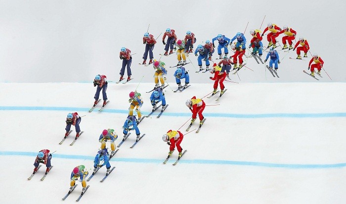 Sweden's Anna Holmlund (green bib), Canada's Kelsey Serwa (red bib), Austria's Katrin Ofner (blue bib) and Switzerland's Fanny Smith (yellow bib) competes during the women's freestyle skiing skicross semi-finals at the 2014 Sochi Winter Olympic Games in Rosa Khutor, 21 February. Multiple Exposure