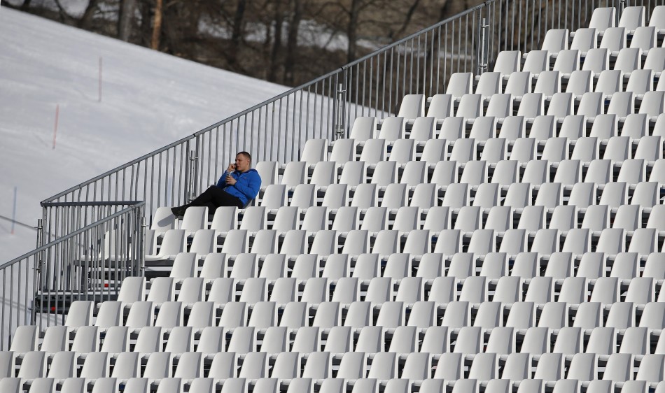 A spectator sits in an empty tribune at the downhill run of the women's alpine skiing super combined event during the 2014 Sochi Winter Olympics, 10 February. Empty Seats