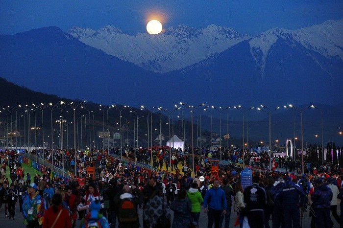 The moon rises over the mountains behind the public entrance to the Olympic Park at the 2014 Sochi Winter Olympics, 14 February. Almost Full Moon