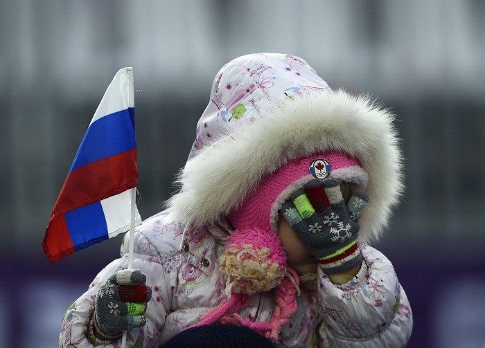 A girl wipes her face while holding a Russian flag during the men's freestyle skiing moguls qualification round at the 2014 Sochi Winter Olympic Games in Rosa Khutor, 10 February. Ardent Russian Fan
