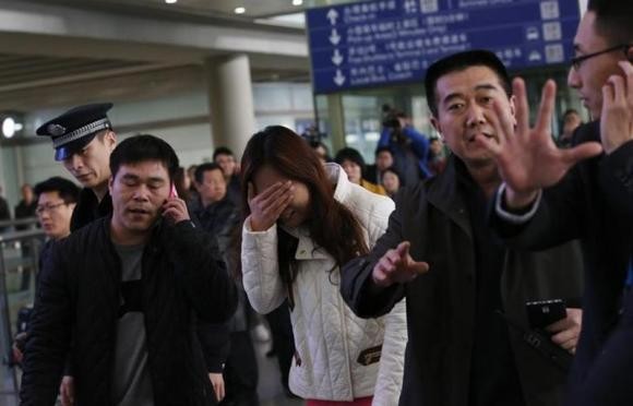 A Relative of a Passenger Onboard Malaysia Airlines Flight MH370, Covers Her Face as She Cries at the Beijing Capital International Airport in Beijing March 8, 2014