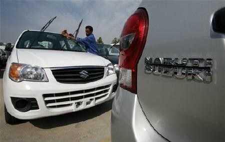 A worker cleans a parked car at the Maruti Suzuki's stockyard on the outskirts of Jammu October 30, 2010.