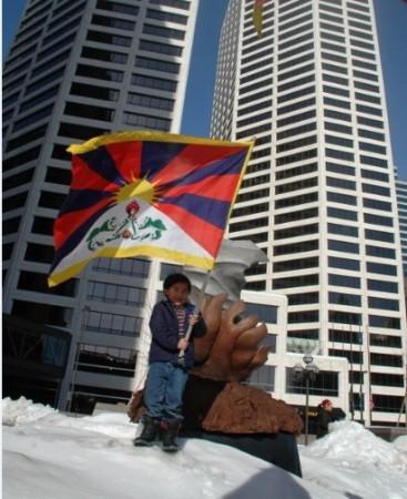 A Tibetan child waves the Tibetan national flag in front of a Twin-tower in Minneapolis, Minnesota, U.S.A. (Photo Credit: Tendar Tsering) A Tibetan child waves the Tibetan national flag in front of a Twin-tower in Minneapolis, Minnesota, U.S.A. (Photo Credit: Tendar Tsering)