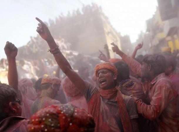 Hindu devotees daubed in colours sing religious songs as they celebrate Lathmar Holi