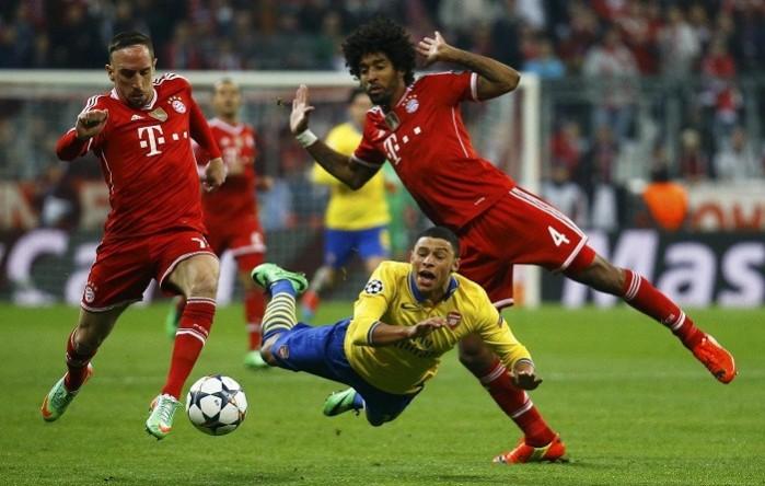 Arsenal midfielder Alex Oxlade-Chamberlain goes down under the challenge of Bayern Munich players Franck Ribery and Dante in their Champions League game, 11 March. Reuters Oxlade-Chamberlain Arsenal Ribery Dante Bayern Munich